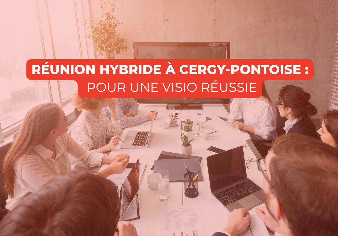 Équipe en salle de réunion devant un écran pour une visioconférence (réunion hybride)